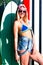 Charming blond girl surfer wearing sunglasses posing in summer with surf