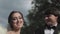 Charming bride in gorgeous wedding dress hold bouquet and stand in front of blooming trees