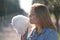 Charming caucasian girl walks in the spring Park in a denim jacket and eats pink cotton candy, smiles at the morning sunlight