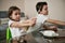 Charming children holding paintbrushes ready for decorating Easter eggs with paints