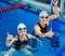 Charming coach with his student swimming in the pool