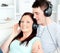 Charming couple listening to music with headphones