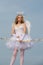 Charming curly little girl in white dress and wings - angel cupid girl. Child with angelic character - Valentine concept