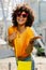 Charming curly woman in heart-shaped sunglasses radiating happiness