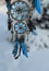 Charming decoration of dreamcatcher with blue feathers and key agains snow landscape.