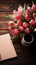 Charming display Tulips and notepad neatly placed on wooden table