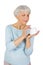Charming elderly woman applying cosmetic cream on her face for facial skin care on a white background.