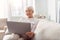 Charming elderly woman reading email on her laptop