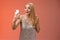 Charming elegant nice blond girl in silver dress talking video call speaking looking smartphone display amused surprised