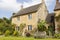 Charming english cottage with colorful flowers in front garden