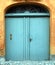 Charming entrance with blue wooden doors topped by a curved glass mosaic in Denmark