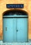 Charming entrance to a pharmacy with blue wooden doors topped by a curved glass mosaic in Denmark