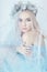 Charming fairy woman in a blue ethereal dress and a wreath on her head on white background, gentle mysterious blonde girl