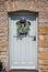 Charming garland with straw squirrel surrounded by grasses and flowers hanging on wooden  front door