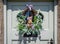 Charming garland with straw squirrel surrounded by grasses and flowers hanging on wooden front door