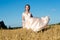 Charming girl in beautiful beige dress in field rye