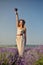 Charming girl in lavender field posing as Statue of Liberty
