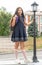 A charming girl with long curly dark hair in a school uniform . Back to school. Vertical photo