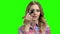 Charming girl puts on makeup on the green screen.