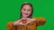 Charming girl showing heart shape with hands looking at camera smiling on green screen. Close-up front view portrait of