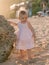 Charming girl in stylish dress on sandy beach with sunset tones