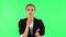 Charming girl takes off glasses, looks around, covers her mouth with her hand and whispers the secret. Green screen