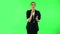 Charming girl takes off glasses, looks around, covers her mouth with her hand and whispers the secret. Green screen