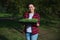 Charming hardworking mature multiracial woman gardener smiles holding cassette with arugula sprouts cultivated on black soil in