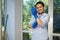 Charming housewife maid, homemaker putting on blue rubber work gloves to clean the house. Housekeeping. Chores. Cleaning