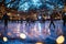 charming ice rink illuminated by twinkling lights, where children are learning to ice skate under the guidance of their