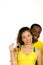 Charming interracial couple wearing yellow football shirts, posing for camera holding beer glass and smiling, white