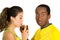 Charming interracial couple wearing yellow football shirts, posing for camera while woman drinks from beer glass and man