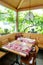 Charming and inviting restaurant table with a bay window and grapevines behind with colorful place settings