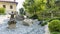 Charming Japanese-style garden with traditional attributes: Oki-gata lantern, gravel paths, boxwood trimmed bushes, maple trees.