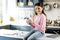 Charming joyful girl drinking tea in kitchen