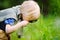 Charming kid exploring nature with magnifying glass