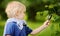 Charming kid exploring nature with magnifying glass