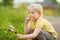 Charming kid exploring nature with magnifying glass