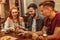 Charming lady and guys sitting at the bar with drinks