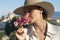 Charming lady stands in a square with stunning views in Florence. Fantastic morning in Italy. Sun hat, flowers, mood of serenity.