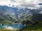 Charming lake with amazing deep colorful water and wild clouds on sky.