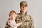 Charming little girl with her military mother, woman soldier holding her daughter, smiling, wearing army uniform, family reunion,