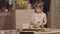 Charming little girl making biscuits at the kitchen table