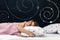 Charming little girl of preschool age sleeps in bed on a pillow with stars. Time to sleep. Abstract background about