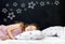 Charming little girl of preschool age sleeps in bed on a pillow with stars. Time to sleep. Abstract background about