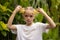 Charming little girl with two slices of fresh starfruit. Caucasian girl holding carambola in her hands. Selected focus. Green