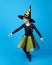 charming little girl in a witch costume dancing in the studio on a blue background