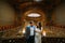 Charming newlywed pair embracing at the background of vintage mansion royal wooden interior
