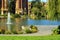 Charming park with winding sidewalk path for walkong the dog in outdoor area with lake and waterfountain spout