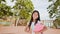 A charming philippine schoolgirl with a backpack and books in a park off the coast. A girl joyfully poses, raising her